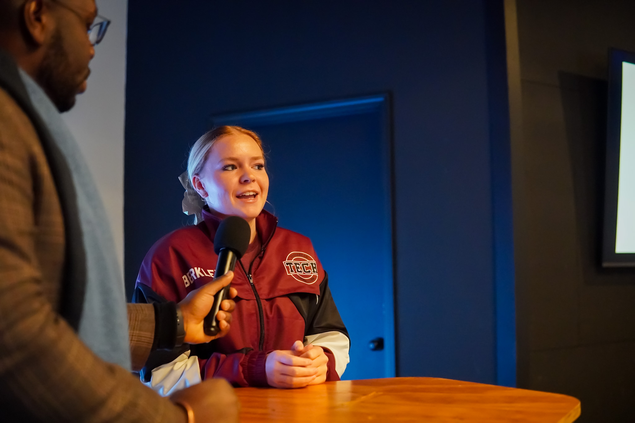 A student is answering a question on stage during a Jackson Grown meeting.