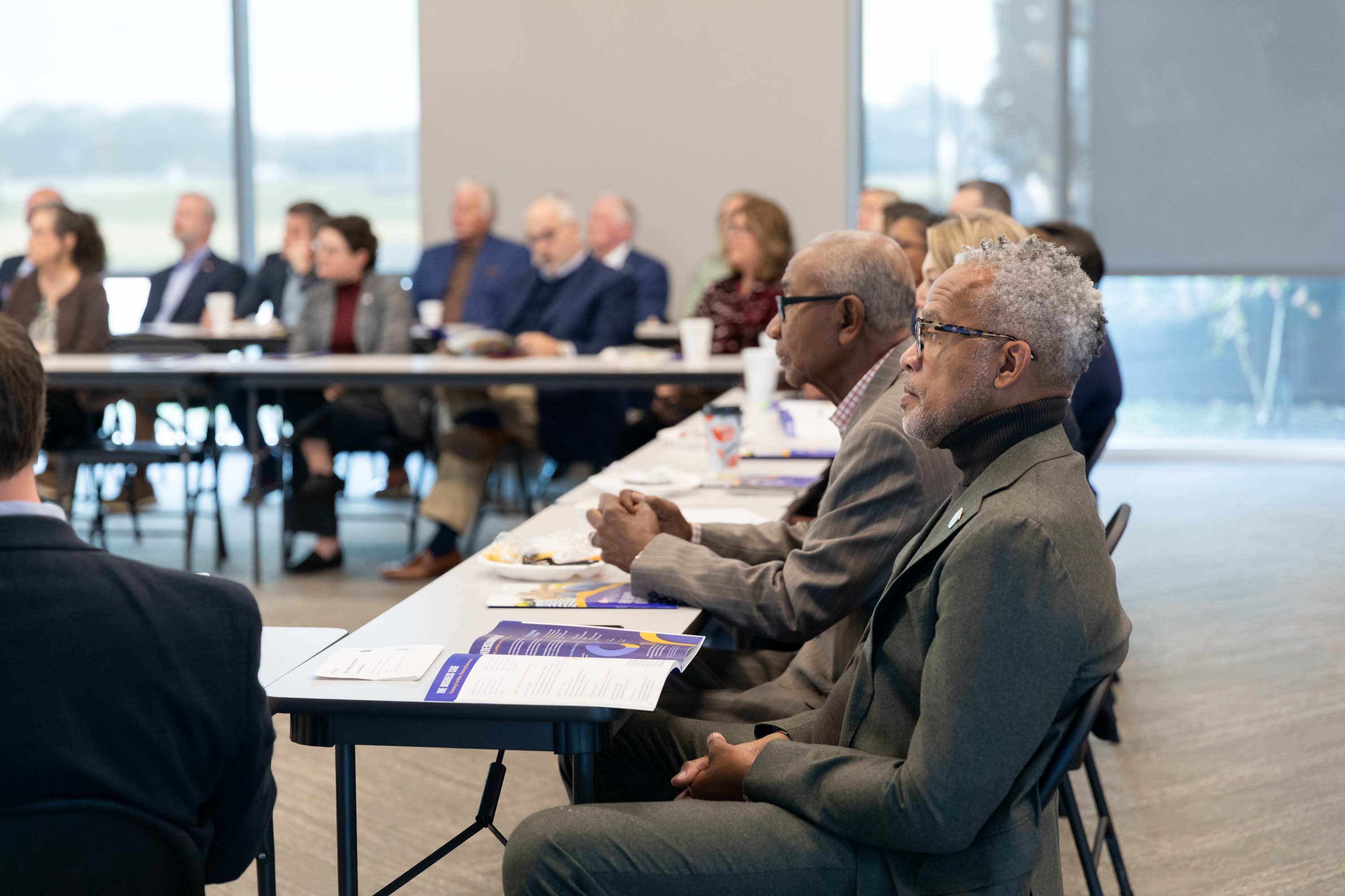 Attendees are listening to the speaker at the Executive Breakfast
